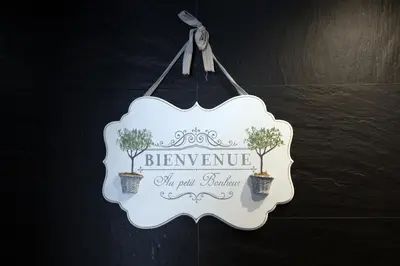 a sign hanging on a wall with two plants at Barcaccia Luxury Suites in Rome