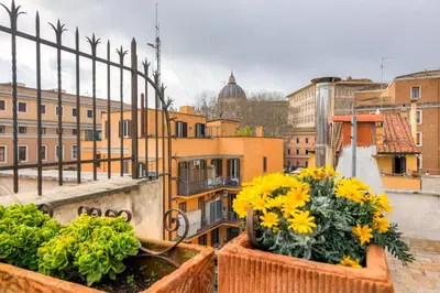 two pots of flowers on a balcony with buildings at Linhouse in Rome