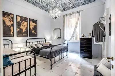 a bedroom with two beds and a chandelier at Ripetta Miracle Suite in Rome