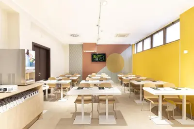 a classroom with tables and chairs in a cafeteria at B&B Hotel Roma San Lorenzo Termini in Rome