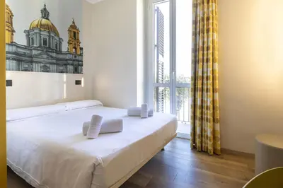 a bedroom with a bed and a large window at B&B Hotel Roma San Lorenzo Termini in Rome