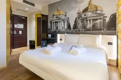a bedroom with a large white bed with towels on it at B&B Hotel Roma San Lorenzo Termini in Rome