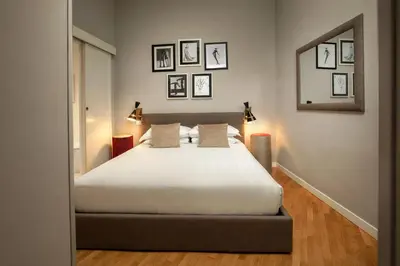 a bedroom with a white bed and some pictures on the wall at Piazza di Spagna Moda Luxury Apartment in Rome
