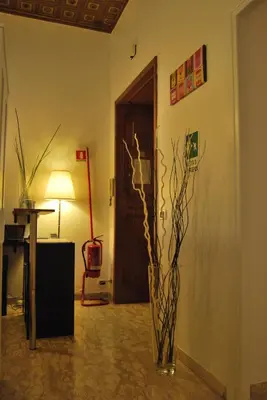 a vase with branches in a room with a door at Core De Roma Suites in Rome