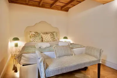 a bedroom with a large bed with a chair at Maddalena 6 - Pantheon in Rome