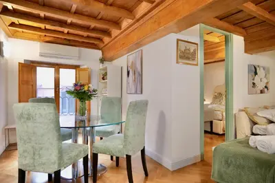 a dining room with a glass table and green chairs at Maddalena 6 - Pantheon in Rome