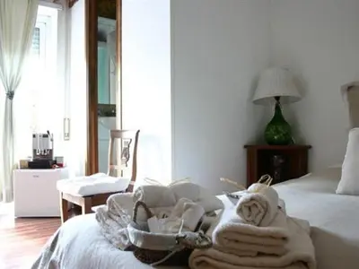 a bedroom with a bed with towels and a robe at Le Fate Apartments in Rome