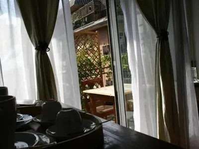 a dining room with a table and a sliding glass door at Le Fate Apartments in Rome