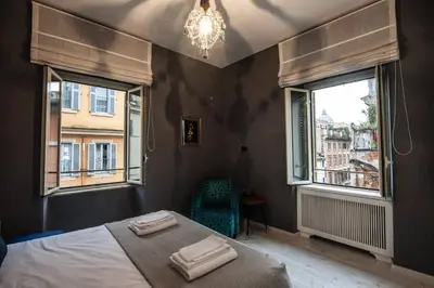a bedroom with a bed and two windows at Vatican Color House in Rome