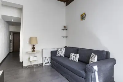 a living room with a blue couch and a table at Emma's Apartment Borgo, Vatican City in Rome