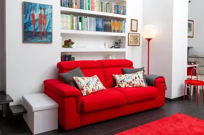 a red couch in a living room with bookshelves at L’ARTSHOP in Rome