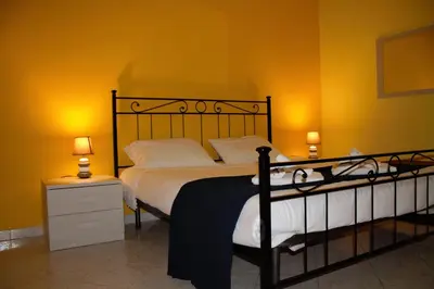 a bedroom with a large bed with yellow walls at Rhome202 in Rome