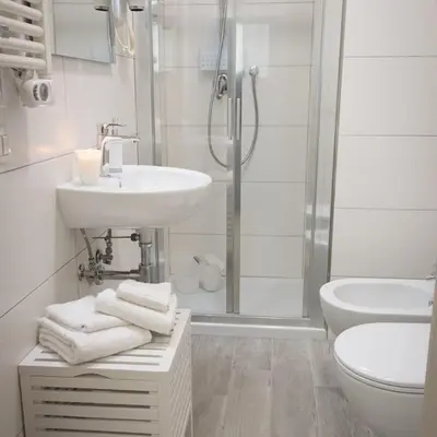 a white bathroom with a sink and a shower at VaticanArt in Rome
