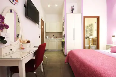 a bedroom with a desk and a bed and a kitchen at Vatication B&B in Rome