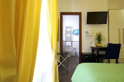 a bedroom with a bed and a desk and a window at Vatication B&B in Rome