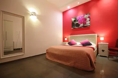 a red bedroom with a bed and a red wall at Vatication B&B in Rome