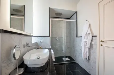 a bathroom with a white sink and a shower at Spagna Luxury Rooms in Rome