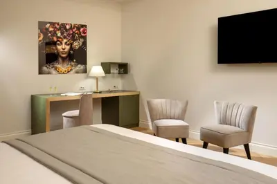 a hotel room with a bed and a desk with two chairs at Spagna Luxury Rooms in Rome