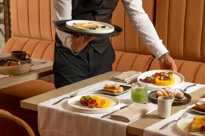 a person holding a plate of food on a table at Spagna Luxury Rooms in Rome