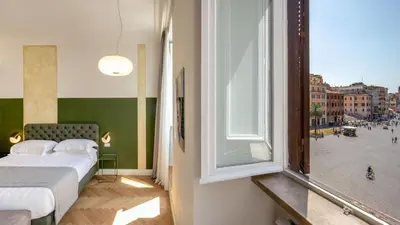 a bedroom with a bed and a large window at Spagna Luxury Rooms in Rome