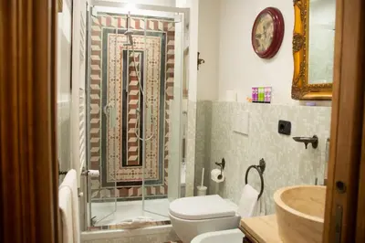 a bathroom with a shower and a toilet and a sink at Dillo Suites in Rome