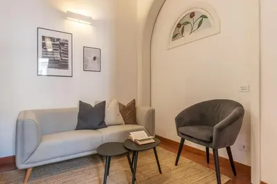 a living room with a couch and a chair at Lively Roma Trastevere renovated apartment - FromHometoRome in Rome
