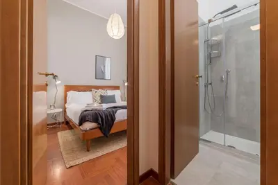 a bedroom with a bed and a glass shower at Lively Roma Trastevere renovated apartment - FromHometoRome in Rome