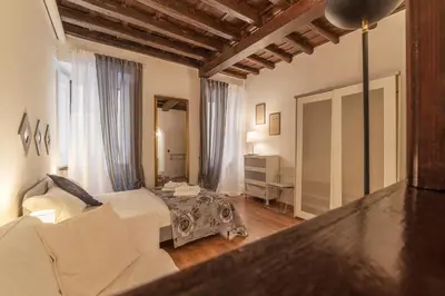 a bedroom with a bed and a couch and a mirror at GuestHost - Fori Imperiali Apartment in Rome
