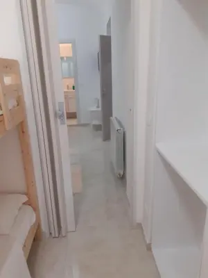 a hallway of a white room with a radiator at ABID'S PALACE IN TERMINI in Rome