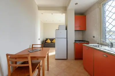a kitchen with a table and a white refrigerator at Crosti Apartments in Rome