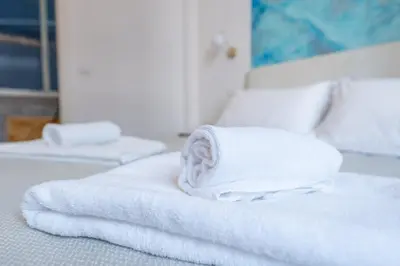 a stack of white towels sitting on a bed at Palazzo Pamphili Lecca di Guevara in Rome