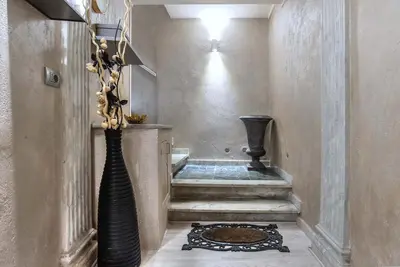 a hallway with a vase on the floor and a staircase at Black And White Suite in Rome