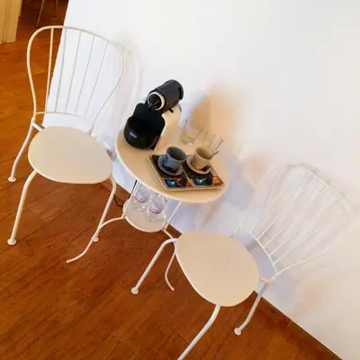 two white chairs and a table with a bottle on it at Clemy In Rome in Rome