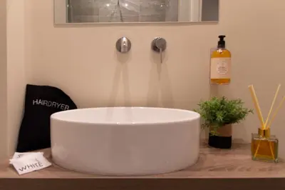 a white sink on a counter with a bottle of wine at Prati 25.7 Suites in Rome in Rome