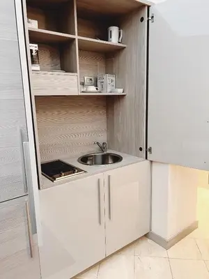 a small kitchen with a sink and a refrigerator at Harry's Bar Trevi Luxury Apartments - Mignanelli in Rome