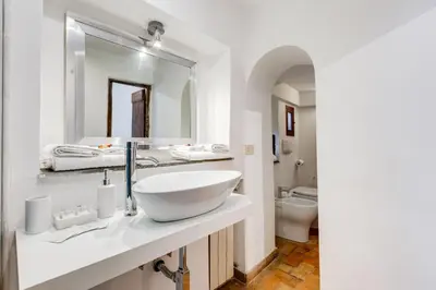 a white bathroom with a sink and a mirror at LIVING COLOSSEUM in Rome
