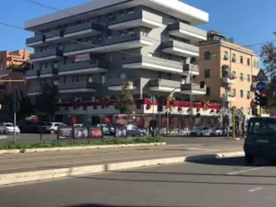 a building on the corner of a street with a car at LIVING ROME Int 2 in Rome