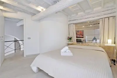 a white bedroom with a large bed with a mirror at Restart Accommodations Borghese in Rome