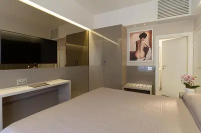 a bedroom with a bed and a flat screen tv at Harry's Bar Trevi Luxury Apartments - Spagna in Rome