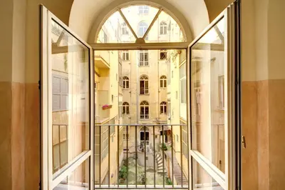 a bedroom with a white bed with purple pillows at B&B Colosseo Panoramic Rooms in Rome