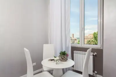 a white table and chairs in a room with a window at B&B Colosseo Panoramic Rooms in Rome