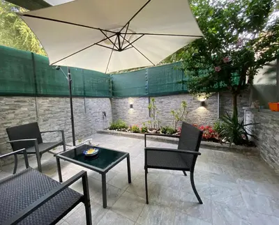 a patio with a table and an umbrella at Mimma's House Private Garden near Trastevere in Rome