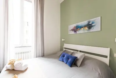a bedroom with a bed with blue pillows at Domus Victoria Guest House in Rome