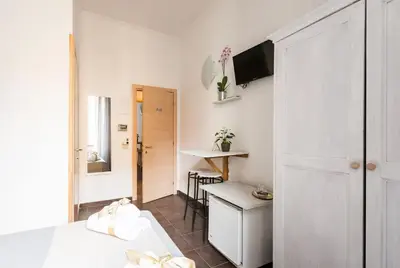 a small room with a bed and a desk in it at Domus Victoria Guest House in Rome