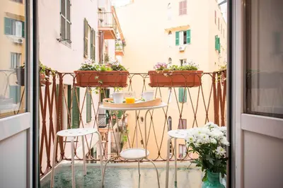 a balcony with a table and chairs and flowers at Domus Victoria Guest House in Rome