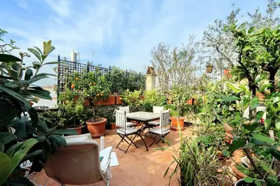 a patio with a table and chairs in a garden at TreasureRome Daphne Terrace in Rome