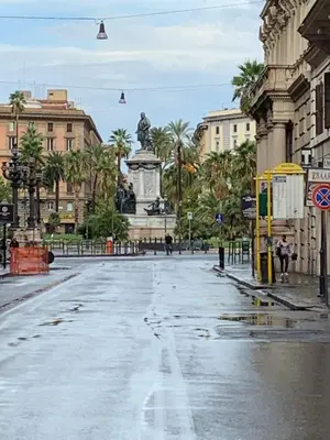 an empty city street with a statue in the middle at TIME in Rome