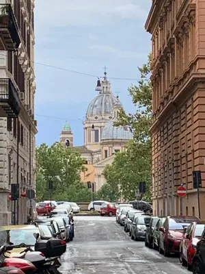 a city street with parked cars and a cathedral at TIME in Rome
