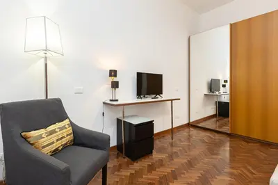 a living room with a chair and a desk with a television at TIME in Rome