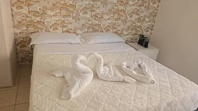 a bed with two swans made to look like towels at TIBURTINA INN GUEST HOUSE in Rome